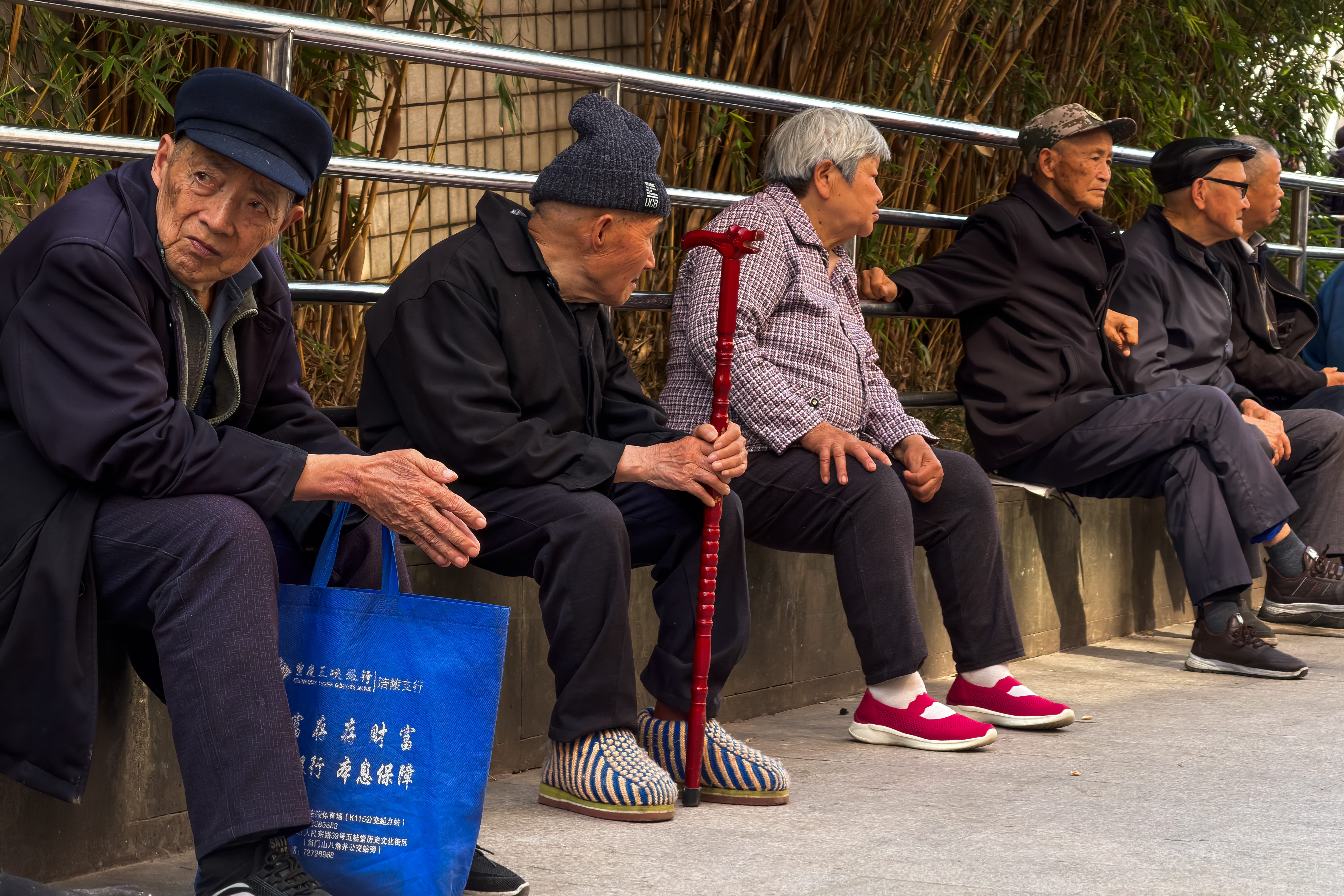 重慶の歩道で休む高齢住民たち。中国都市での公共屋外スペースは高齢者の重要な集会場所となっている。